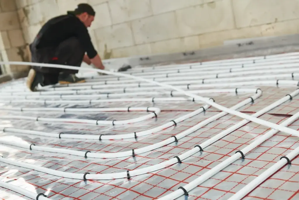 Underfloor heating pipes being installed for energy-efficient home retrofitting.